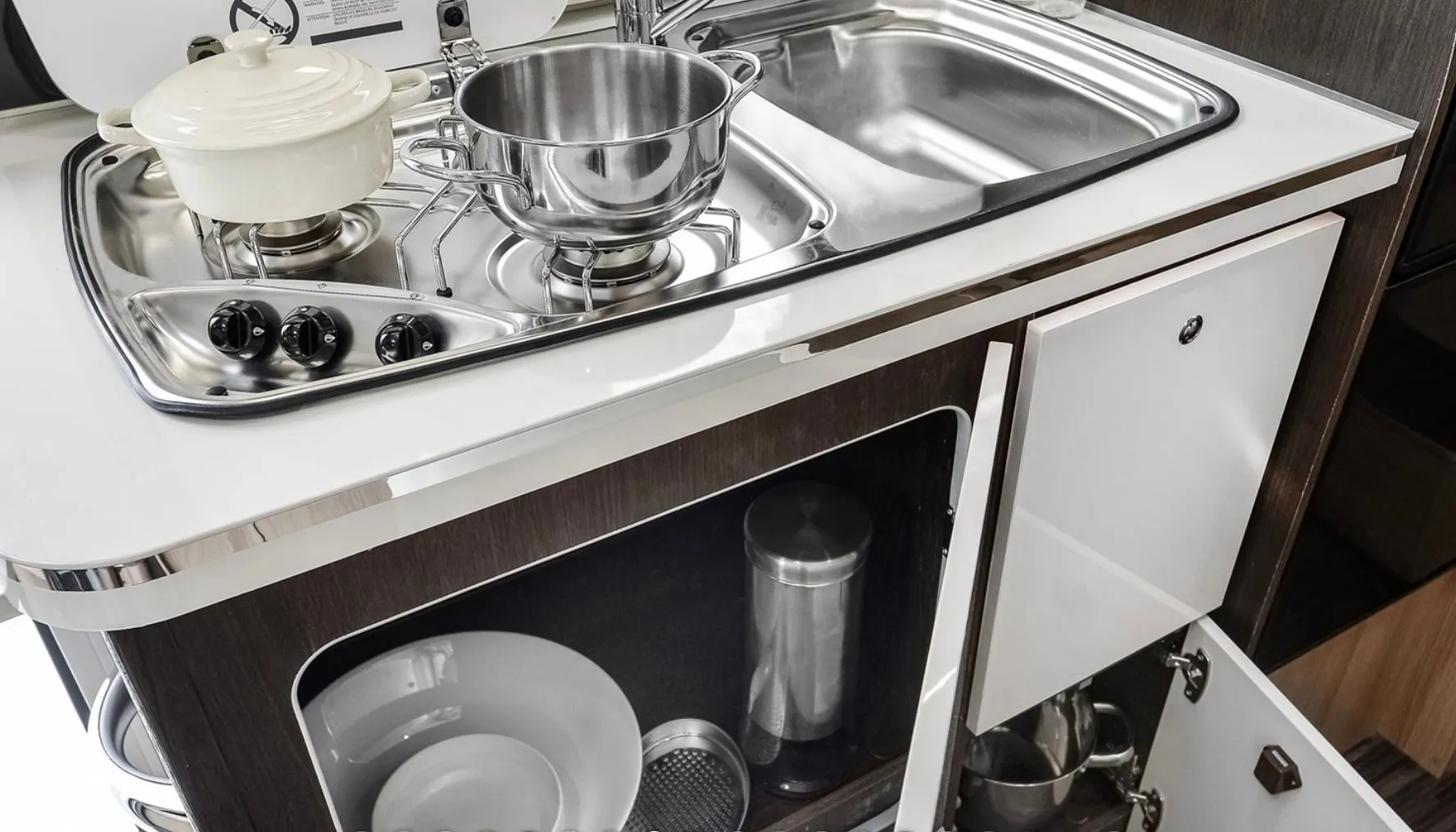 Cocina equipada con fogones, fregadero y menaje